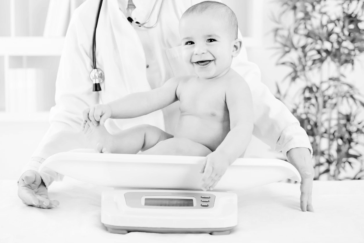 A pediatrician smiling with a happy baby