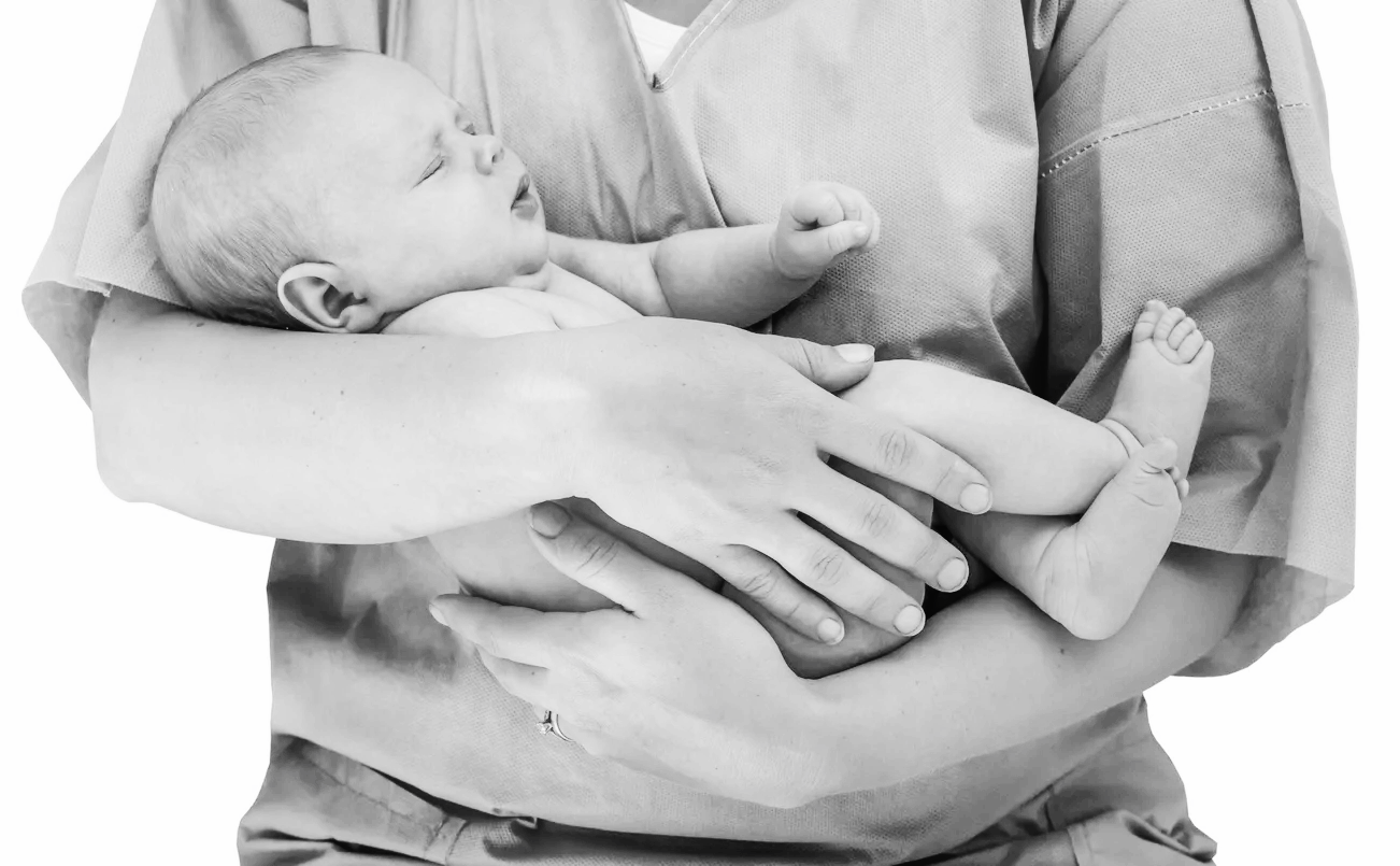 A parent holding a sleeping newborn